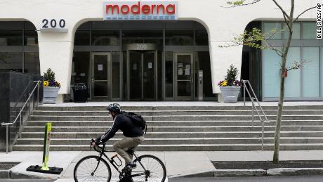 A bicyclists pedals past an entrance to a Moderna, Inc., building, Monday, May 18, 2020, in Cambridge, Mass. Moderna announced Monday that an experimental vaccine against the coronavirus showed encouraging results in very early testing, triggering hoped-for immune responses in eight healthy, middle-aged volunteers. (AP Photo/Bill Sikes)
